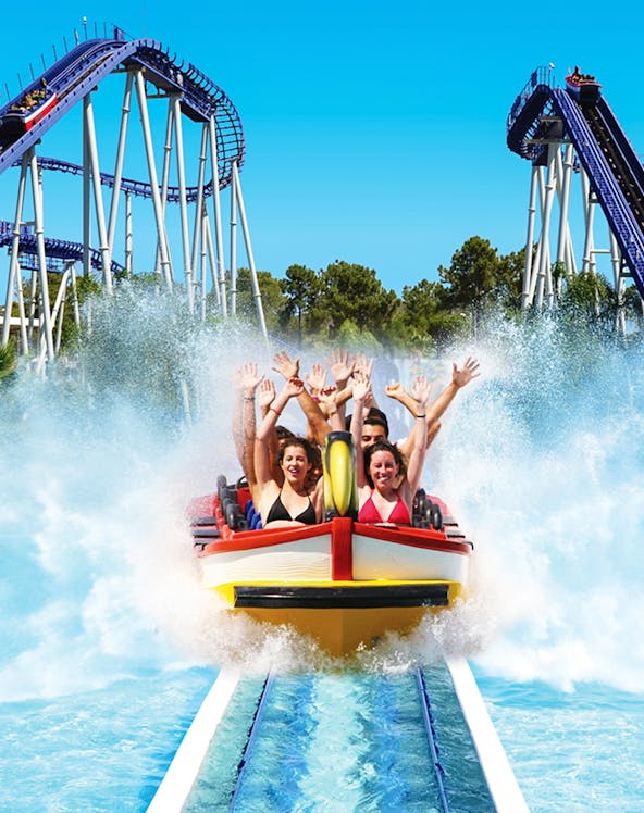 Roller coaster splash ride at Aquashow Park with people raising hands.