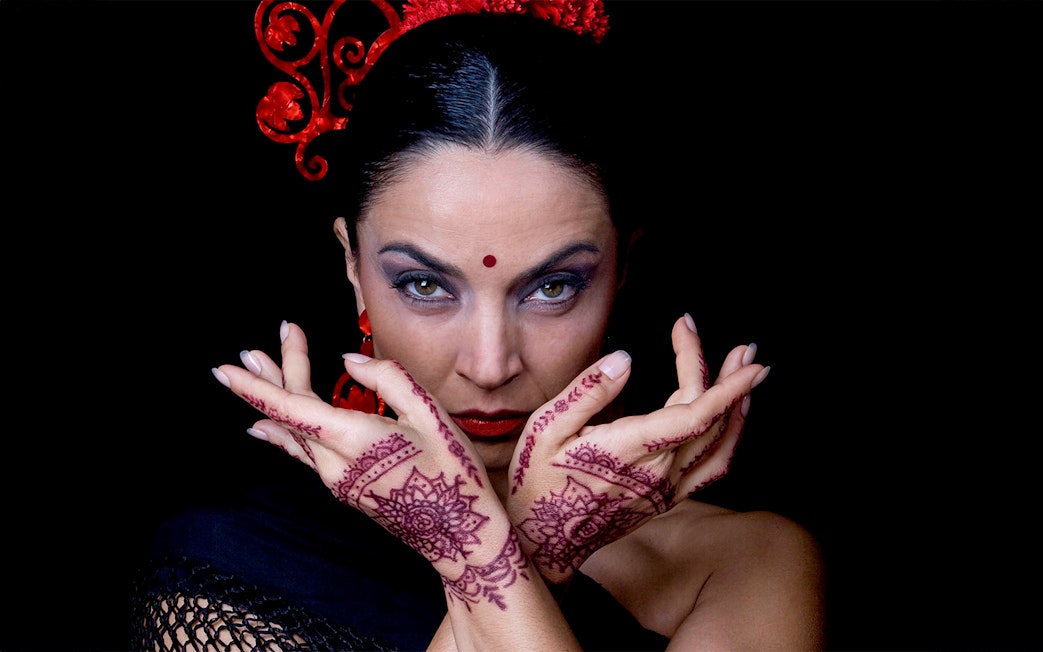 Flamenco dancer with henna designs on hands at Sensaciones Teatro Flamenco Granada.