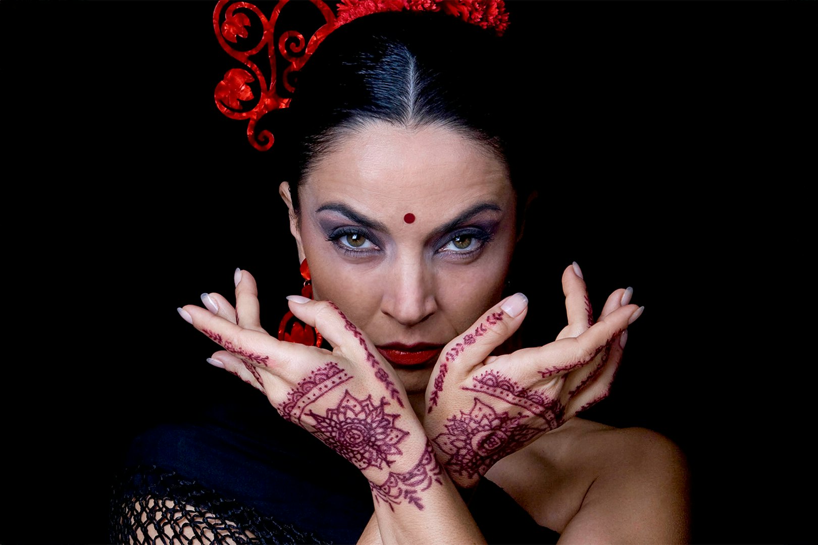 Flamenco dancer with henna designs on hands at Sensaciones Teatro Flamenco Granada.