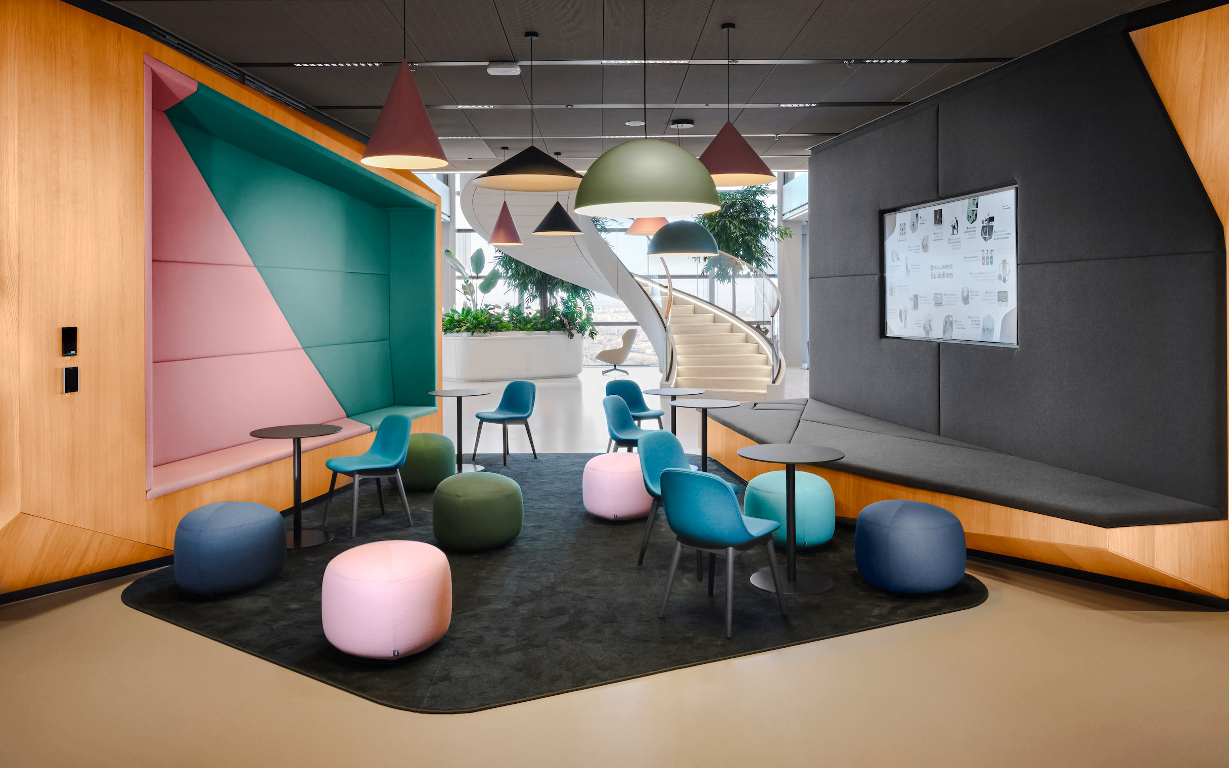 Modern seating area with colorful chairs and poufs at MOL Campus interior.
