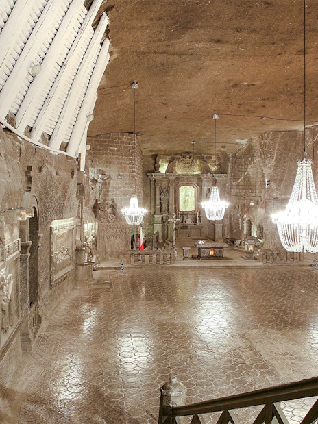 Wieliczka Salt Mine chapel with chandeliers and carved salt statues.