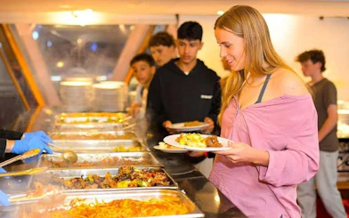 Guests serving themselves at a buffet on a Cairo Nile dinner cruise.