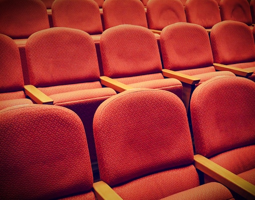 Rows of red seats in the Lords Chamber at Houses of Parliament.