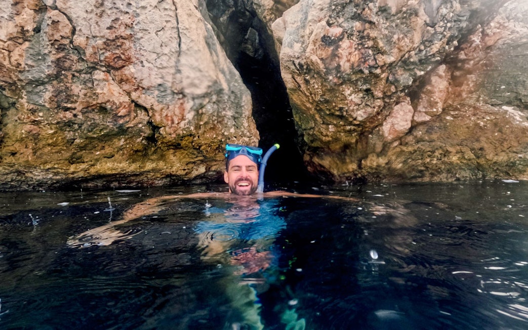 Snorkeler enjoying Blue Lagoon tour near rocky cliffs, Hvar.
