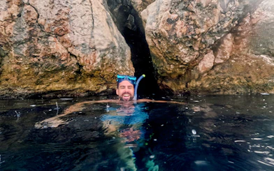 Snorkeler enjoying Blue Lagoon tour near rocky cliffs, Hvar.