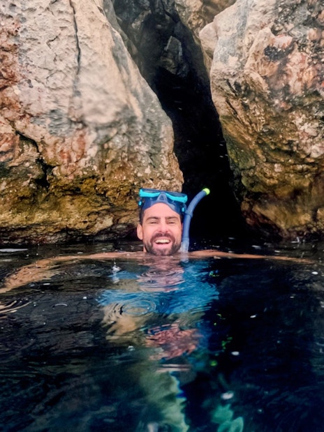 Snorkeler enjoying Blue Lagoon tour near rocky cliffs, Hvar.