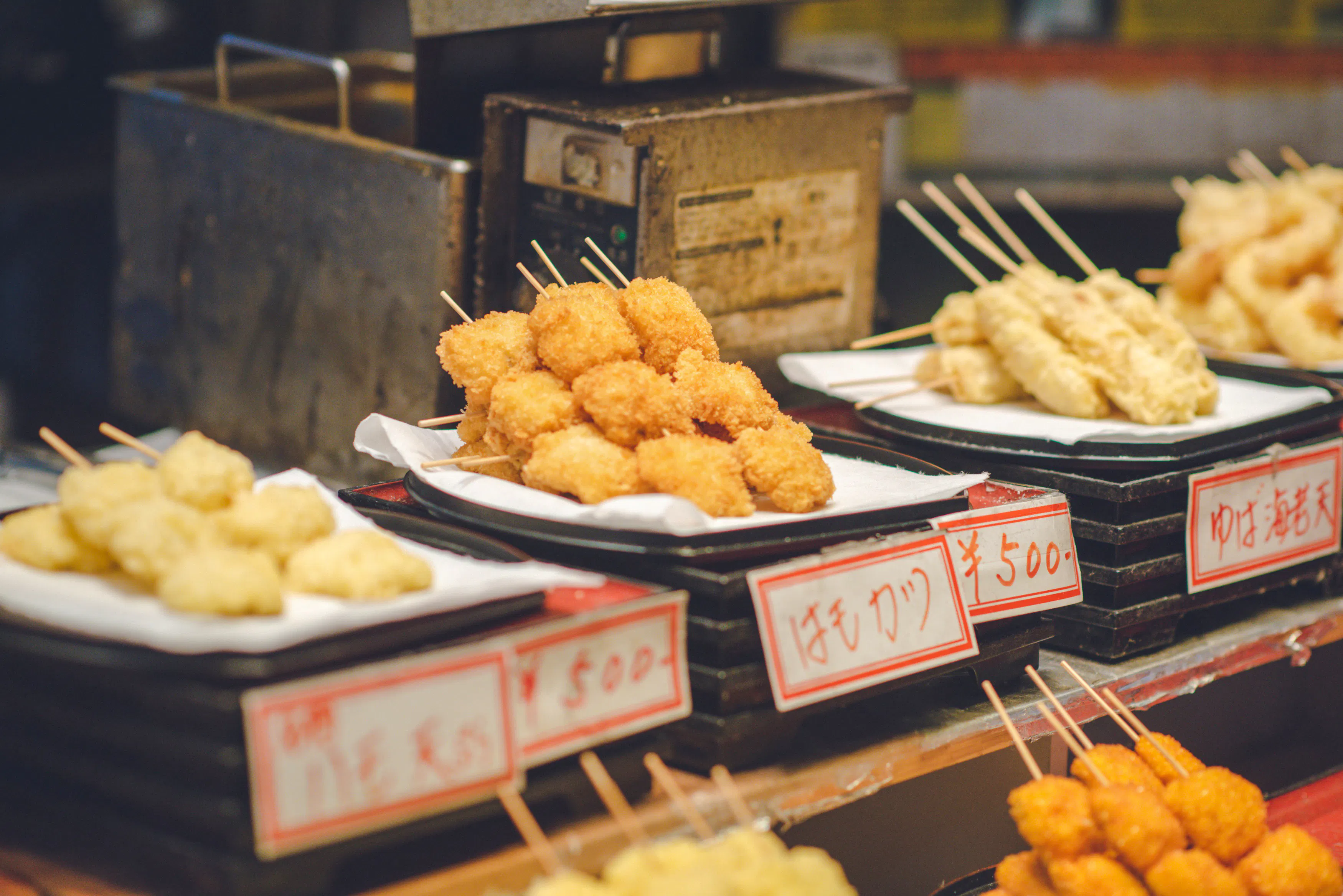 Street food skewers on display at a market stall in Osaka, Japan.