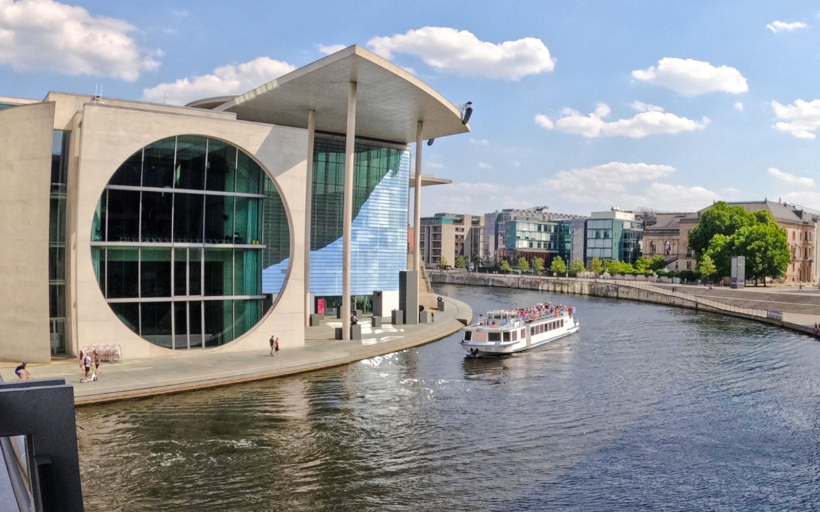 Berlin boat cruise passing the German parliamentary complex on a sunny day.