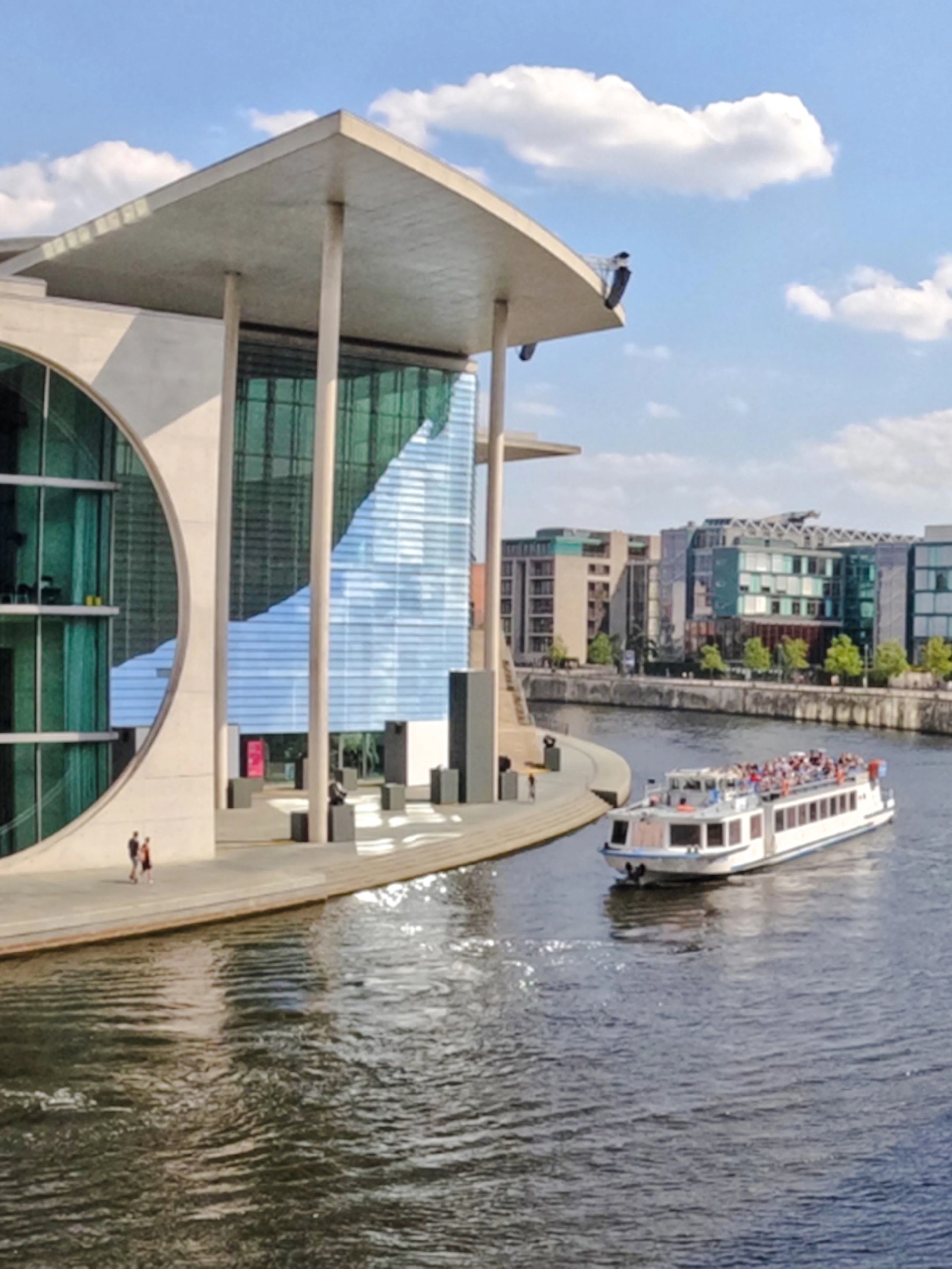 Berlin boat cruise passing the German parliamentary complex on a sunny day.