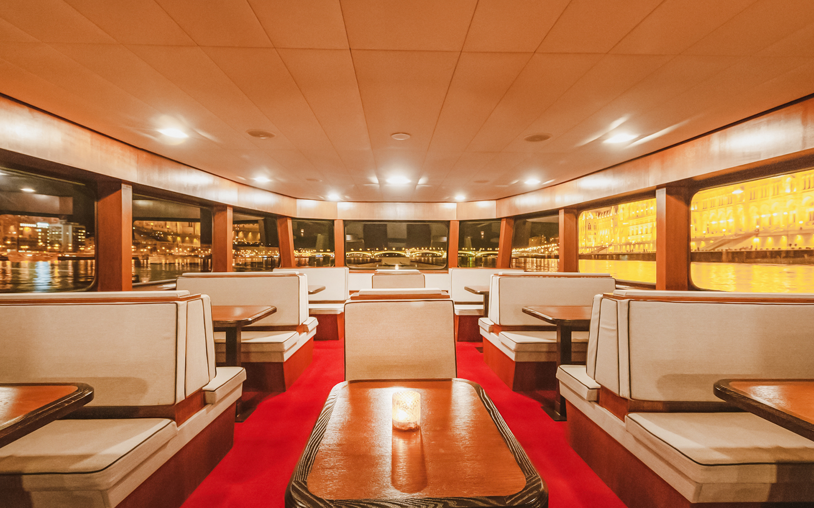 Budapest Danube River cruise interior with passengers enjoying nighttime city views.