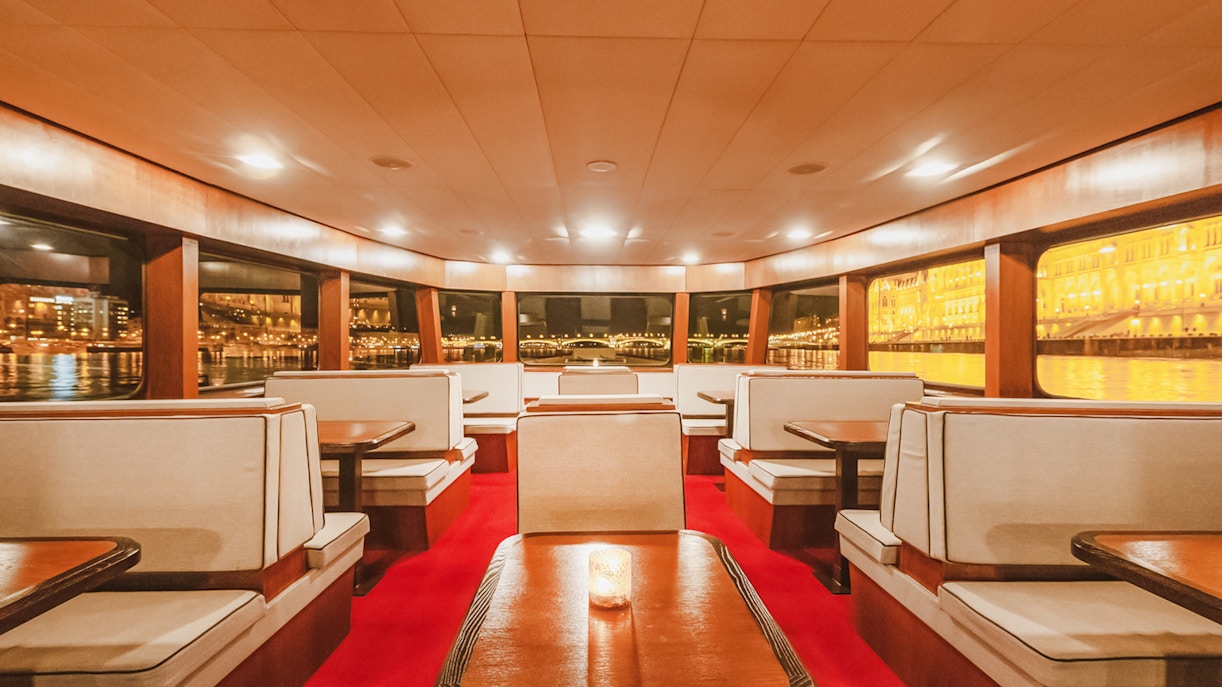 Budapest Danube River cruise interior with passengers enjoying nighttime city views.