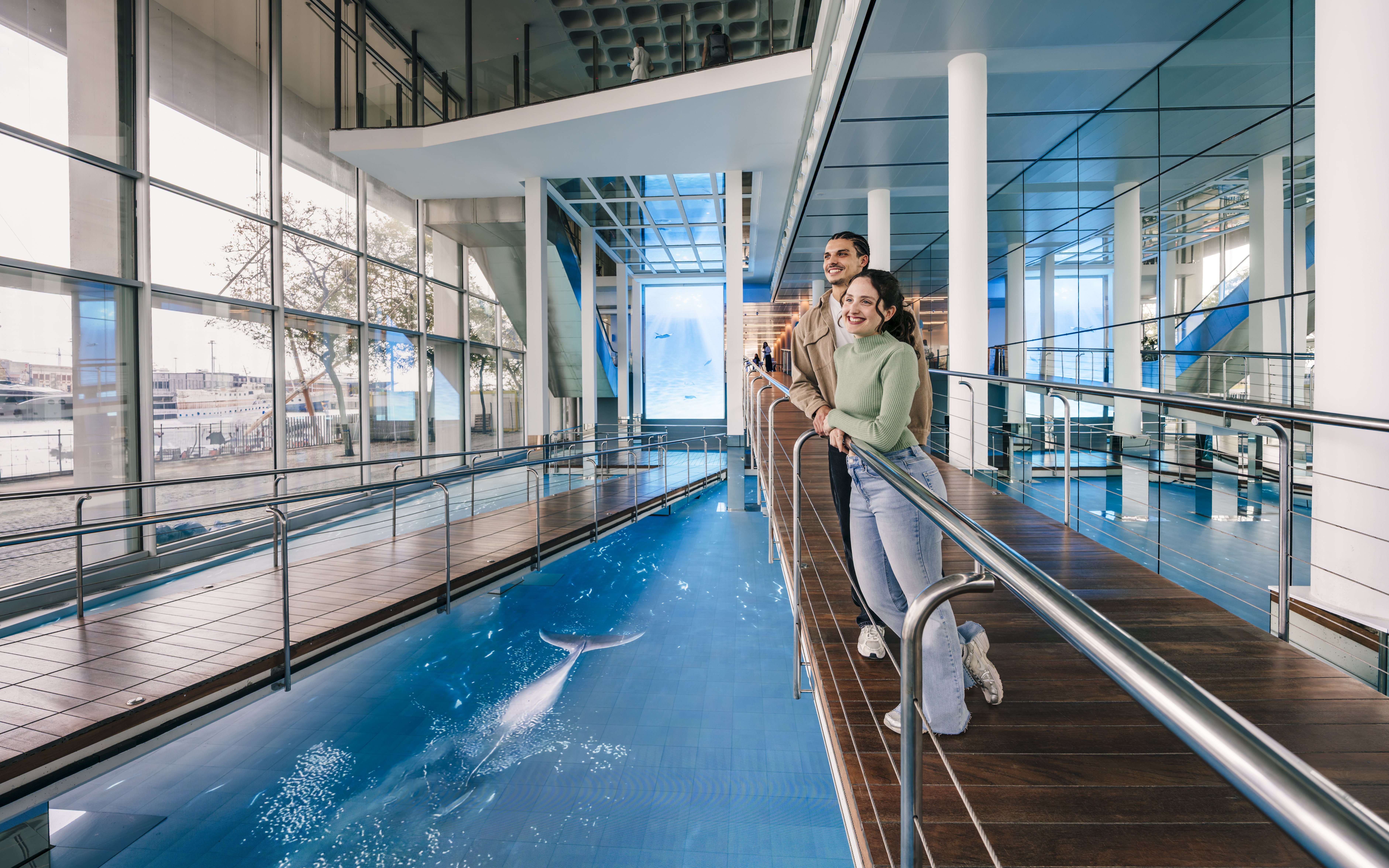 Tourists enjoying the view inside the Barcelona Aquarium.