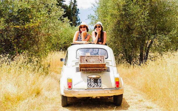 Vintage Fiat 500 with two people on a countryside road near Florence.
