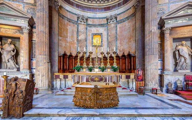 Main altar of the Pantheon in Rome with ornate carvings and golden candlesticks.