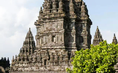 Prambanan Temple complex with detailed stone carvings and lush greenery.