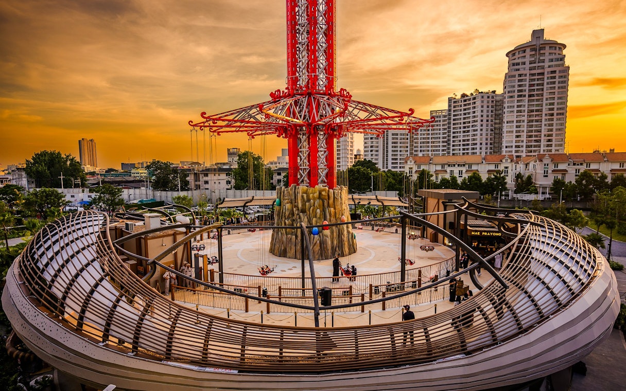 SkyFlyer ride at Asiatique Bangkok during sunset with city skyline in the background.