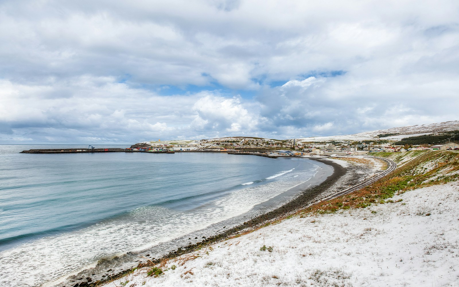 Coastal view of Skjálfandi Bay with a snowy shoreline in North Iceland.