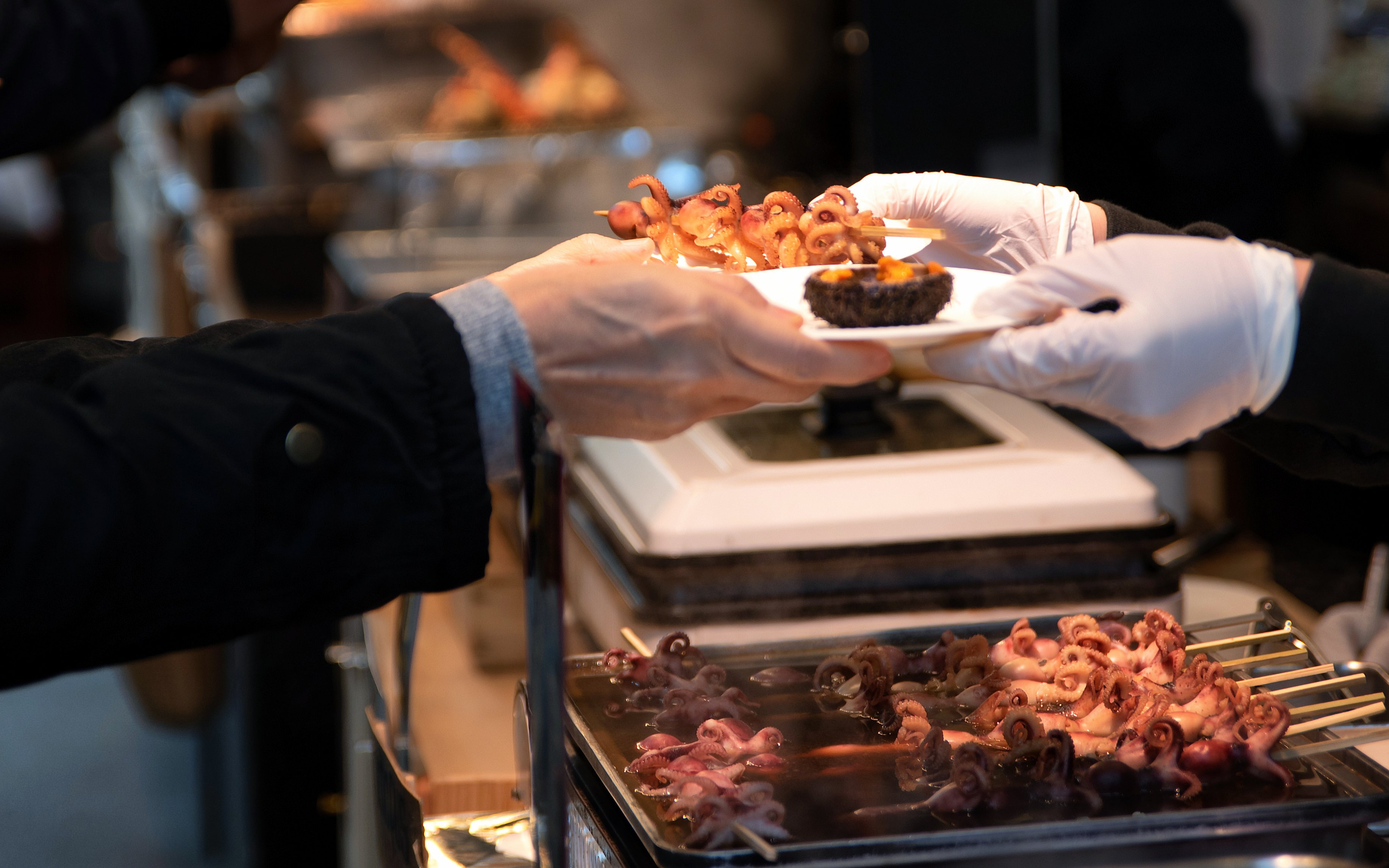 Grilled baby octopus and uni served at Tsukiji Fish Market, Japan.