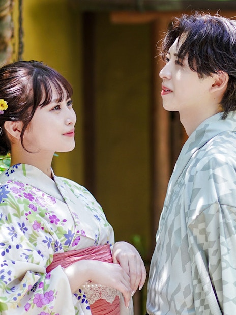 Couple in traditional kimono standing in a Japanese garden.