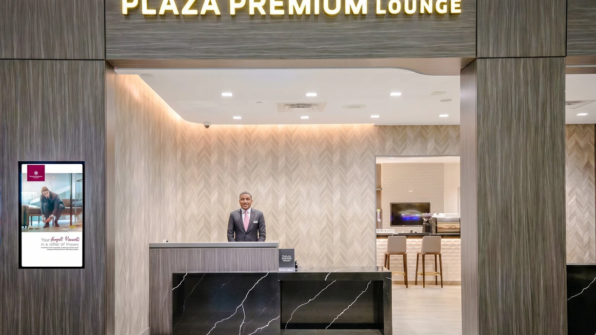 Entrance of Plaza Premium Lounge, Terminal 1, Toronto Pearson Airport, with reception desk and staff.
