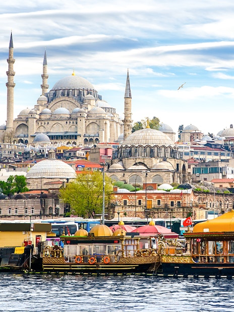 Boats on the Bosphorus with Suleymaniye Mosque in Istanbul, Turkey.