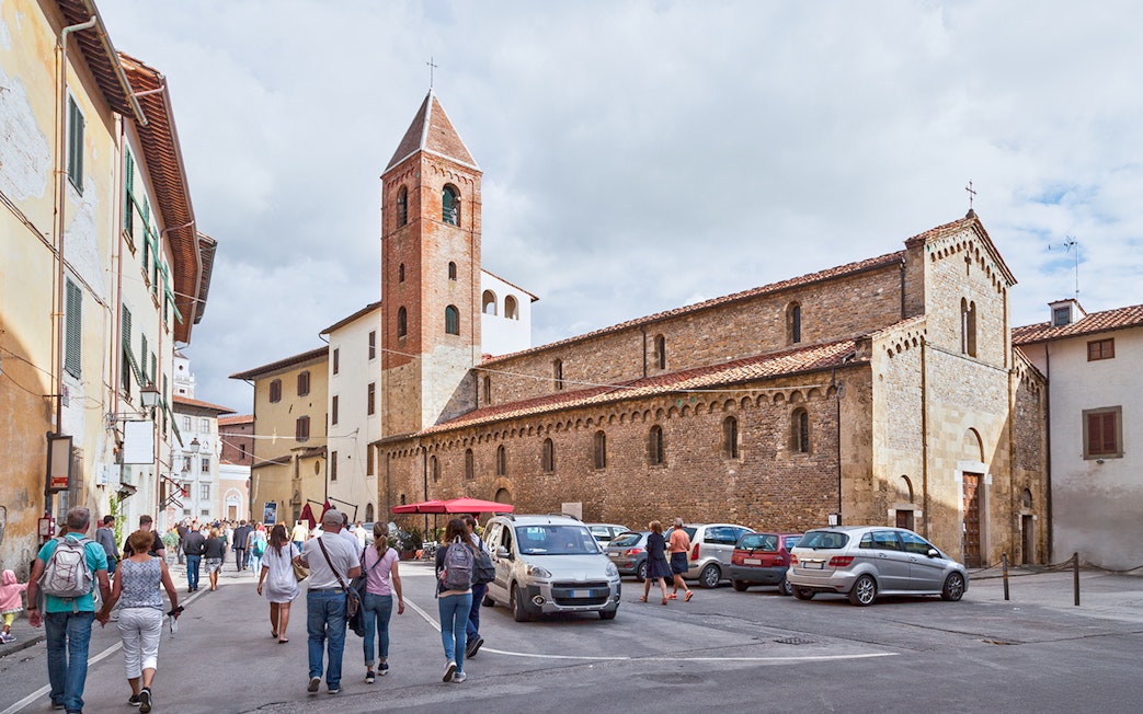 Tourists approaching San Sisto Church in Cortevecchia, Pisa.