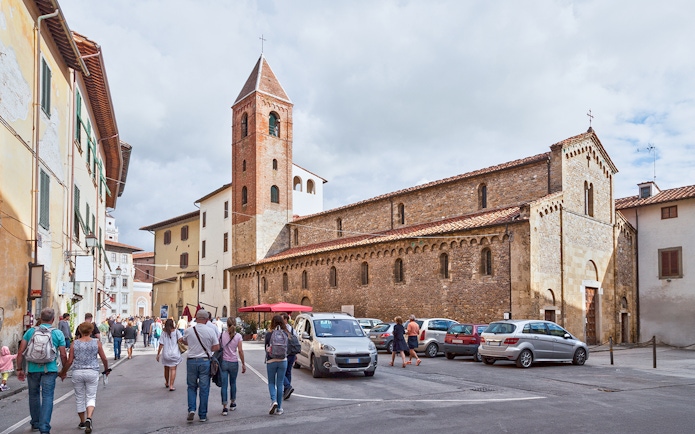 Tourists approaching San Sisto Church in Cortevecchia, Pisa.
