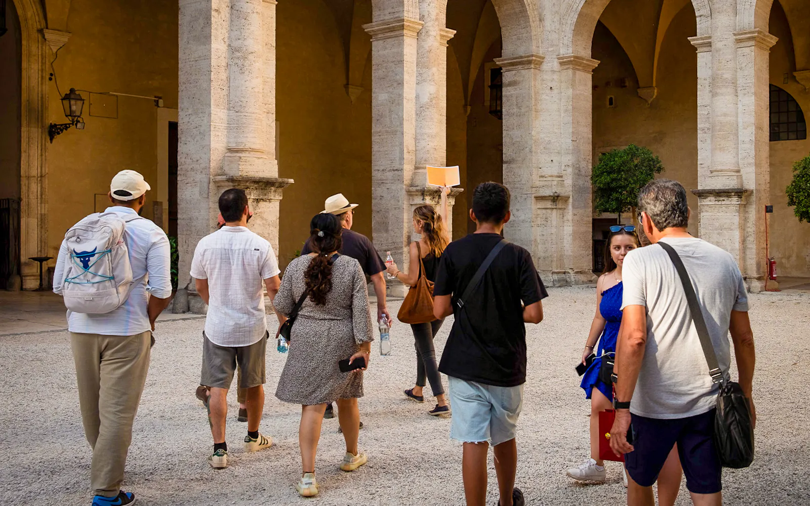 Group of tourists exploring a historic courtyard on a Rome walking tour.