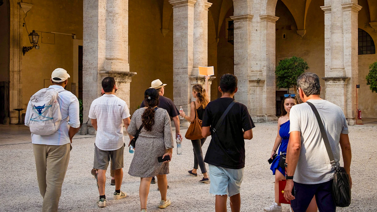 Group of tourists exploring a historic courtyard on a Rome walking tour.