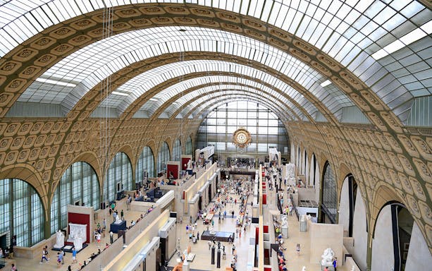 Interior view of Orsay Museum's grand hall with visitors exploring exhibits.