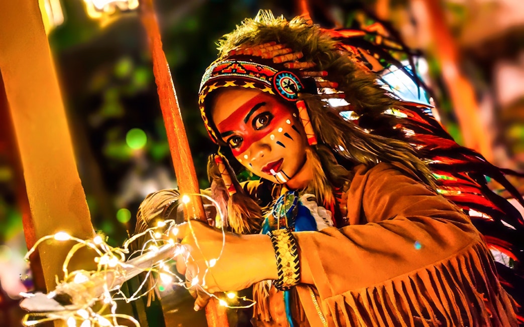 Performer in traditional costume with face paint at Sunway Lagoon Night Park.