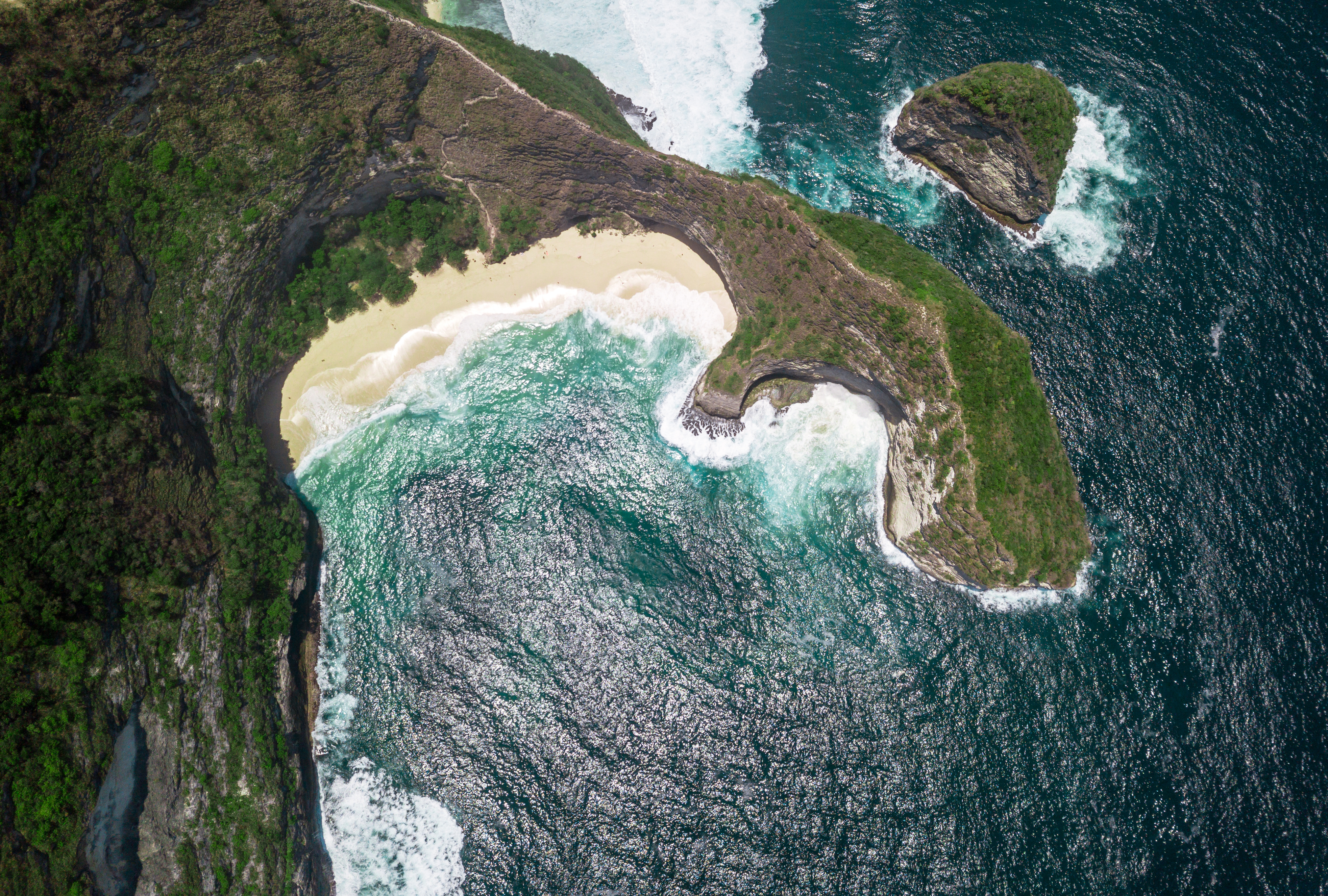 Aerial view of Kelingking Beach's cliff and turquoise waters, Nusa Penida, Bali.