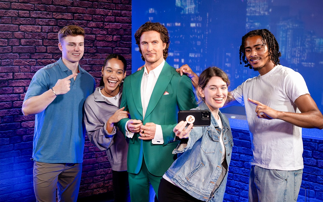 Friends posing with wax figure at Madame Tussauds, New York.