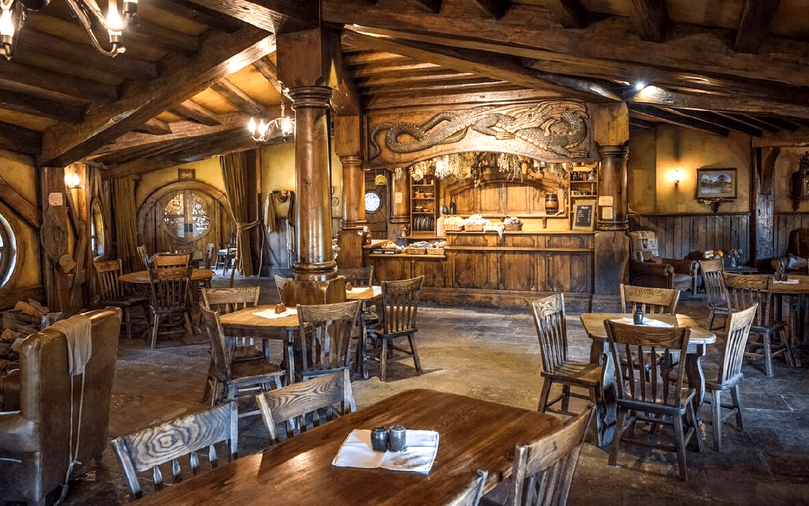 Interior of the Green Dragon Inn at Hobbiton Movie Set with wooden tables and chairs.