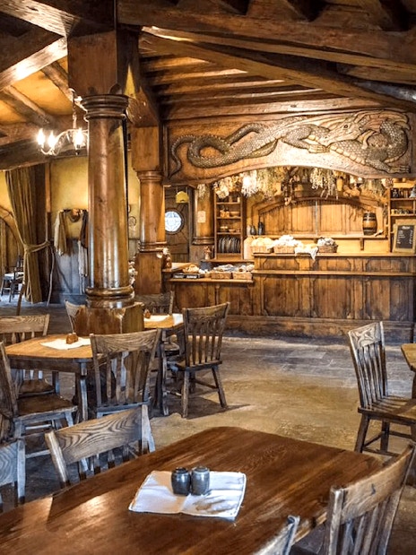 Interior of the Green Dragon Inn at Hobbiton Movie Set with wooden tables and chairs.