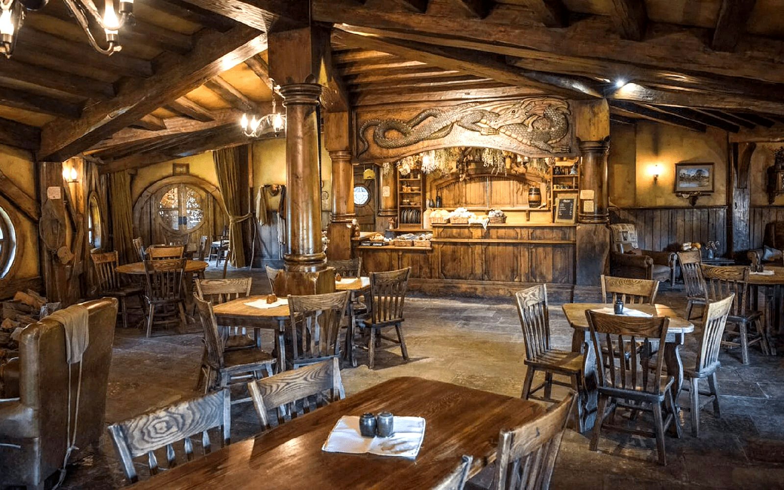 Interior of the Green Dragon Inn at Hobbiton Movie Set with wooden tables and chairs.