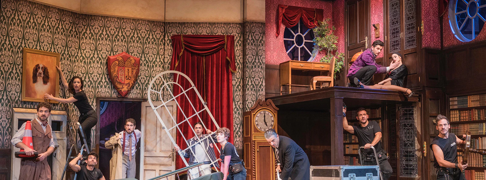 Theater cast performing a chaotic scene in "La Función Que Sale Mal" with props and set pieces.