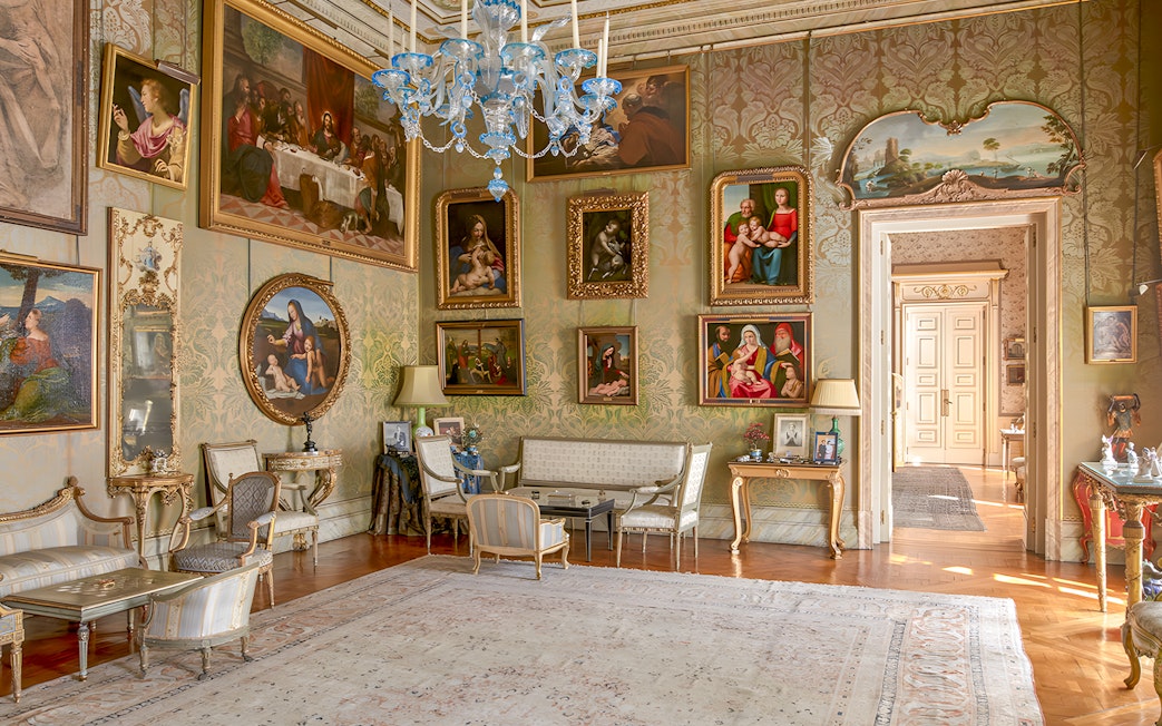 Photos and paintings in an ornate room at Liria Palace, featuring classic art and elegant furnishings.