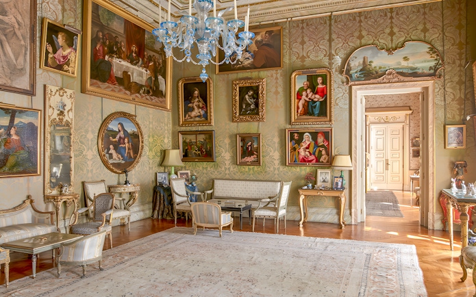 Photos and paintings in an ornate room at Liria Palace, featuring classic art and elegant furnishings.