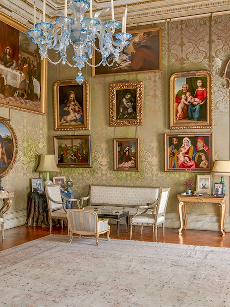 Photos and paintings in an ornate room at Liria Palace, featuring classic art and elegant furnishings.