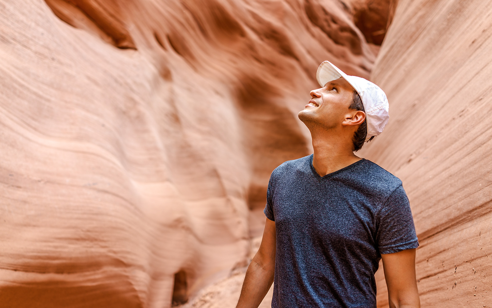 Man admiring sandstone walls in Antelope Canyon, Arizona.