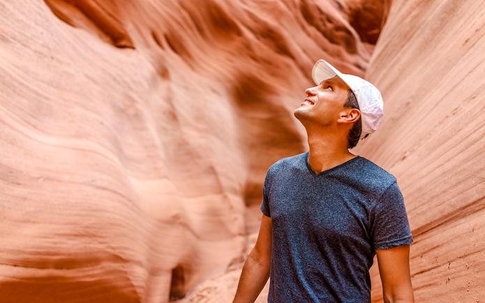 Man admiring sandstone walls in Antelope Canyon, Arizona.