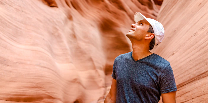 Man admiring sandstone walls in Antelope Canyon, Arizona.