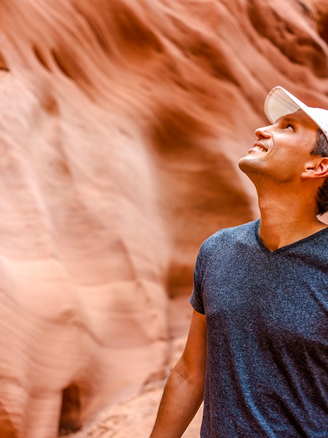 Man admiring sandstone walls in Antelope Canyon, Arizona.