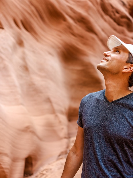 Man admiring sandstone walls in Antelope Canyon, Arizona.