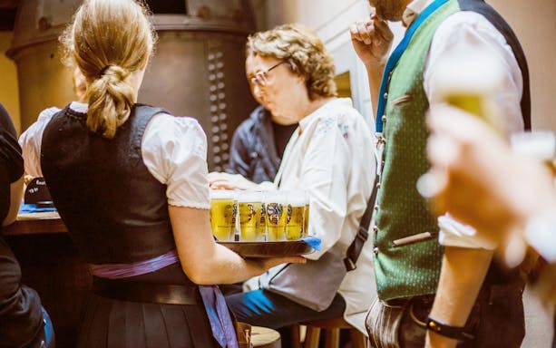 Server carrying beer tray during Munich beer tour.