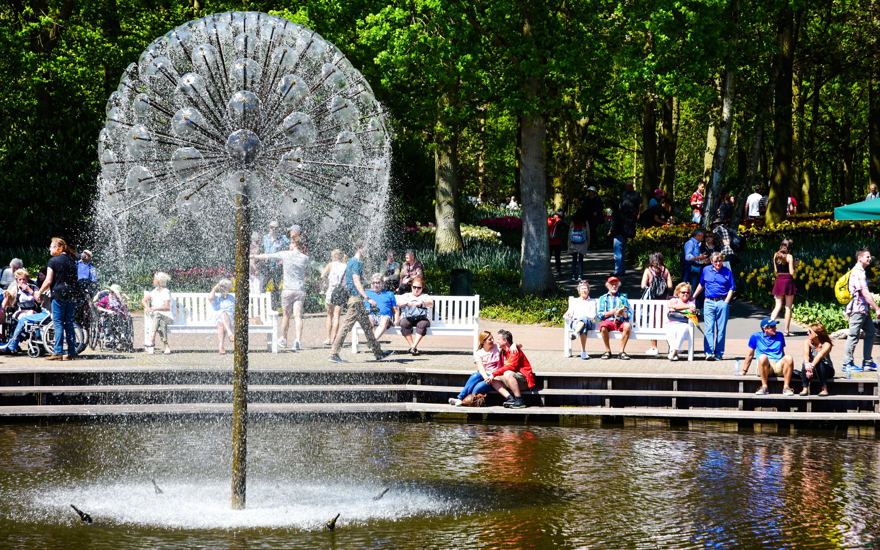Visitors relaxing by a fountain at Keukenhof Gardens, Amsterdam.