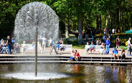 Visitors relaxing by a fountain at Keukenhof Gardens, Amsterdam.