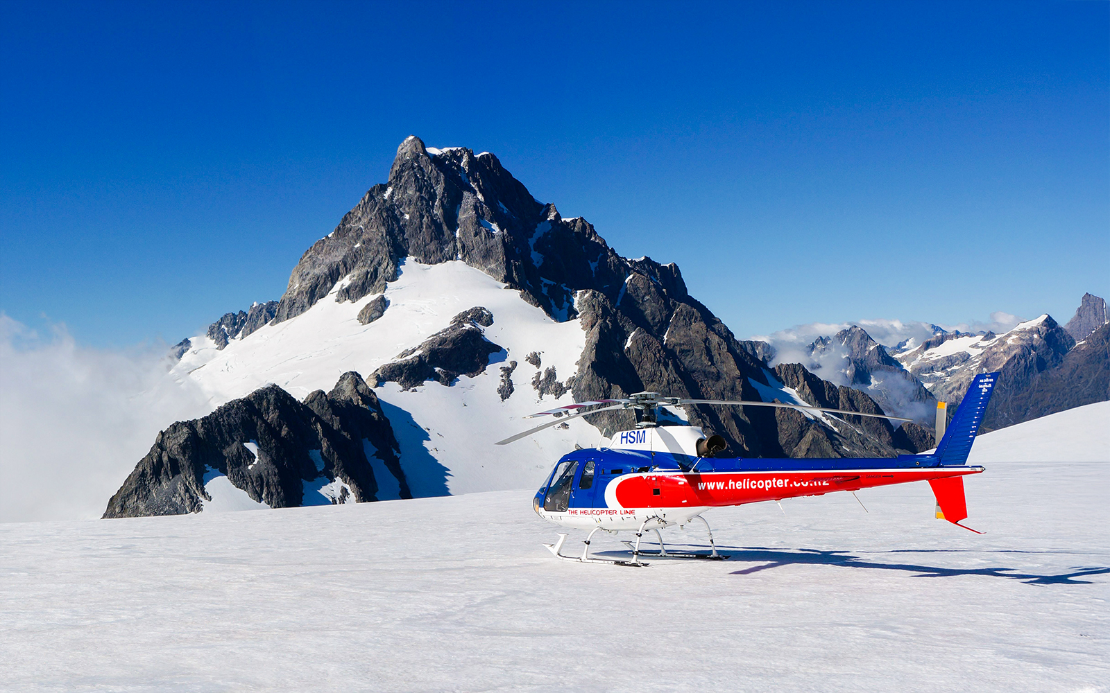 Helicopter flying over glacier during Milford Sound FlyCruiseHeli Tour in Queenstown, New Zealand.