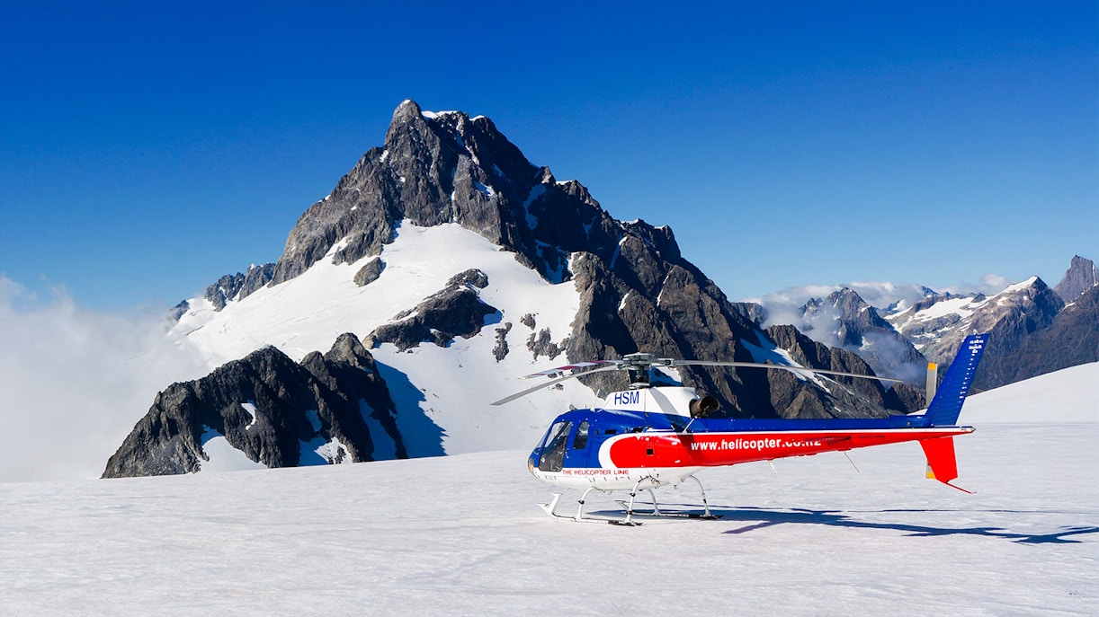 Helicopter flying over glacier during Milford Sound FlyCruiseHeli Tour in Queenstown, New Zealand.